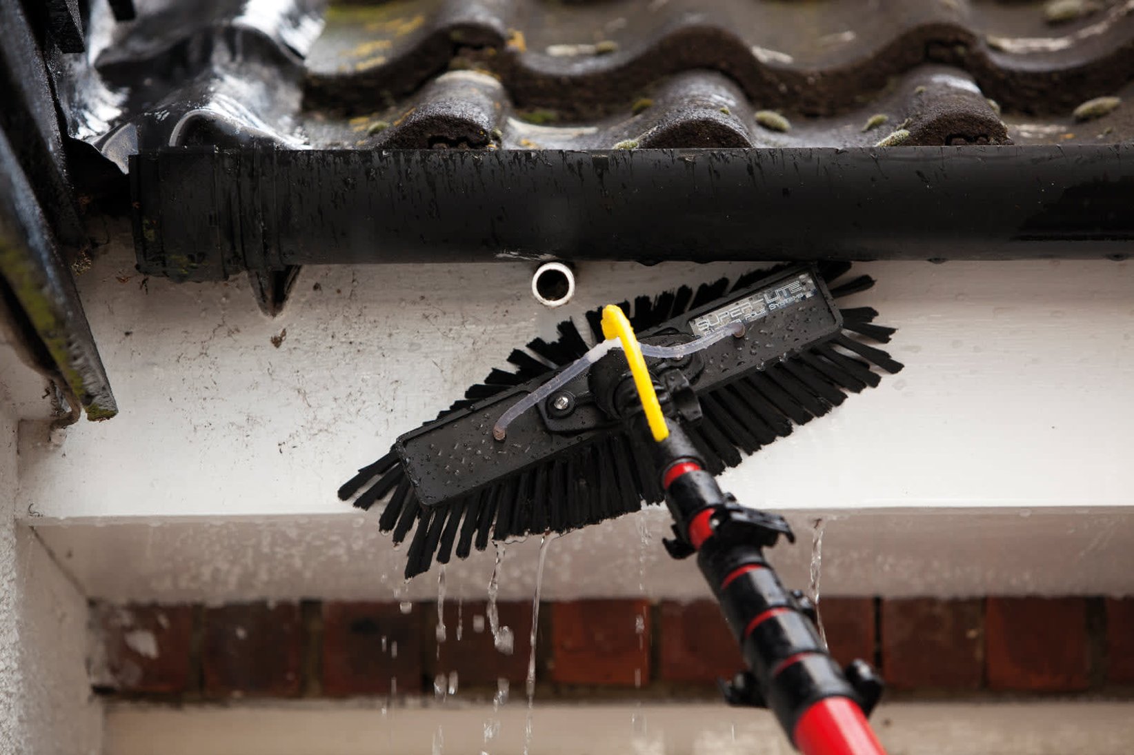 Professional fascia and soffit cleaning using reach and wash purified water system removing algae and grime